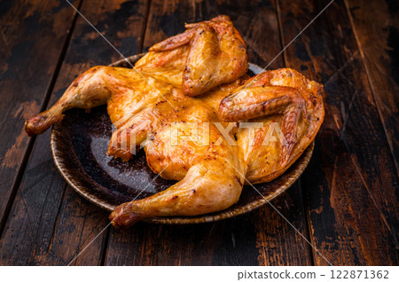 Baked chicken Tabaka Tobacco with spices, poultry meat on plate. wooden background. top view Baked chicken Tabaka Tobacco with spices, poultry meat on plate. wooden background. top view 122871362