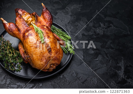 Grilled duck with apples on plate with herbs. black background. top view Grilled duck with apples on plate with herbs. black background. top view 122871363