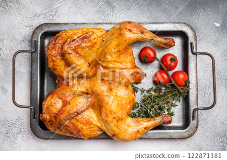 Baked chicken Tabaka with spices, poultry meat on steel tray. white background. top view 122871381