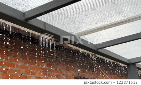 Heavy rain drumming on the transparent plexiglass roof. Beautiful rainy scene on summer day. Concept of tranquility nature scene. Close up Slow motion Heavy rain drumming on the transparent plexiglass roof. Beautiful rainy scene on summer day. Concept of tranquility nature scene. Close up Slow motion 122871512