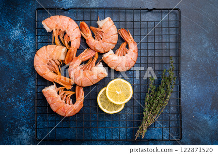 Ready for cooking Headless Red shrimps, raw Prawns on a rack. blue background. top view 122871520