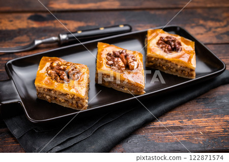 Homemade Walnut Baklava with honey on plate. wooden background. top view 122871574