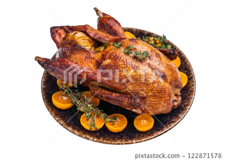 Roast goose with apples and oranges on plate with herbs isolated on white background. top view Roast goose with apples and oranges on plate with herbs isolated on white background. top view 122871578