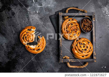 Danish raisin pastry swirls. black background. top view 122871627
