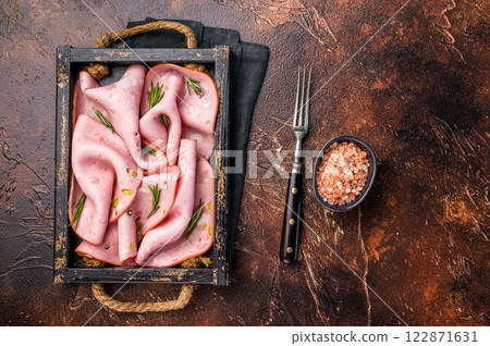 Mortadella Bologna slices with pistachios for breakfast in wooden. brown background. top view 122871631