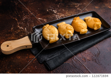Japanese Taiyaki Fish Shaped Waffle with Sweet Paste. brown background. top view Japanese Taiyaki Fish Shaped Waffle with Sweet Paste. brown background. top view 122871694