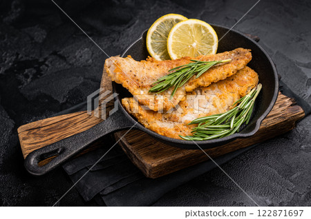 Pan Fried Hake white fish fillet. black background. top view 122871697