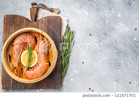 Steamed Red shrimps, Prawns in bamboo steamer. grey background. top view Steamed Red shrimps, Prawns in bamboo steamer. grey background. top view 122871701