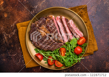 Dinner with Grilled Rib eye steak, fried dry aged beef meat. brown background. top view Dinner with Grilled Rib eye steak, fried dry aged beef meat. brown background. top view 122871712