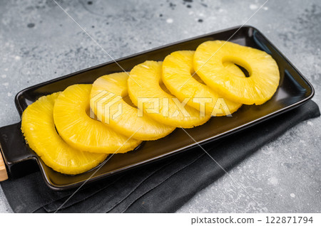 Canned Pineapple rings slices on a board. grey background. top view Canned Pineapple rings slices on a board. grey background. top view 122871794