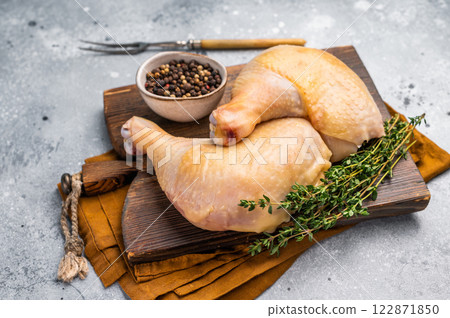 Raw chicken legs on wooden cutting board, eco poultry meat on gray background, top view 122871850