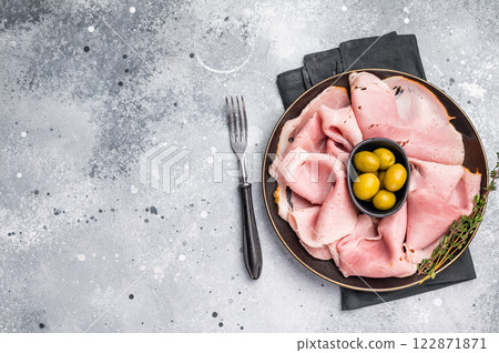 Meat appetizer with Sliced Prosciutto Cotto ham and green olives. grey background. top view Meat appetizer with Sliced Prosciutto Cotto ham and green olives. grey background. top view 122871871