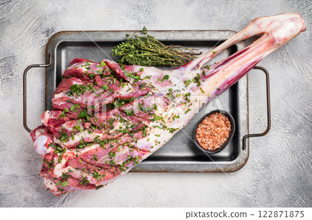 Marinated with herbs and olive oil raw goat leg. white background. top view 122871875