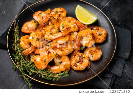 Grilled spicy Shrimps Prawns with garlic and lime in a plate. Black background. Top view Grilled spicy Shrimps Prawns with garlic and lime in a plate. Black background. Top view 122871880