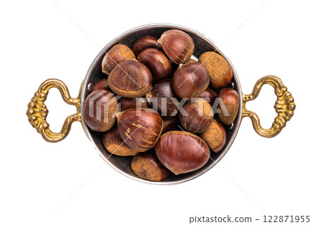 Raw chestnuts in rustic skillet ready for cooking isolated on white background Raw chestnuts in rustic skillet ready for cooking isolated on white background 122871955