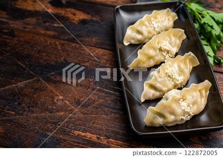 Traditional Chinese Jiaozi Dumplings with pork meat and vegetables. wooden background. top view Traditional Chinese Jiaozi Dumplings with pork meat and vegetables. wooden background. top view 122872005