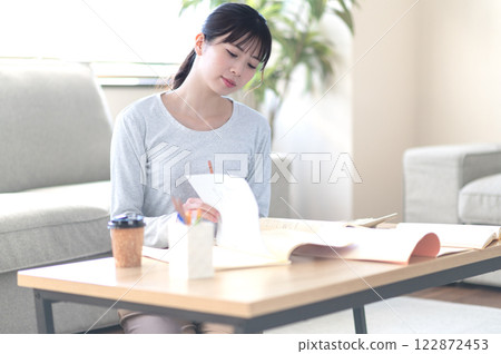 A young woman studying alone in the living room A young woman studying alone in the living room 122872453