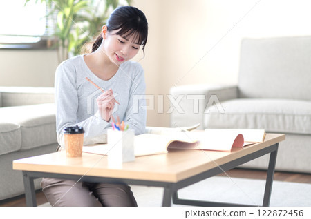 一位年輕女子獨自在客廳學習 122872456