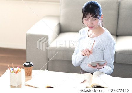 A young woman studying alone in the living room A young woman studying alone in the living room 122872460