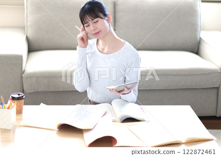 A young woman studying alone in the living room A young woman studying alone in the living room 122872461