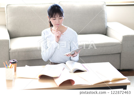 一位年輕女子獨自在客廳學習 122872463