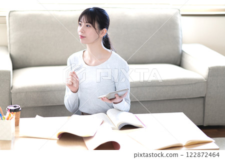 一位年輕女子獨自在客廳學習 122872464