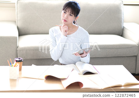 A young woman studying alone in the living room A young woman studying alone in the living room 122872465