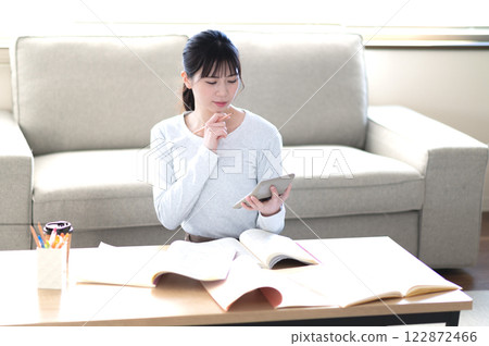 A young woman studying alone in the living room A young woman studying alone in the living room 122872466