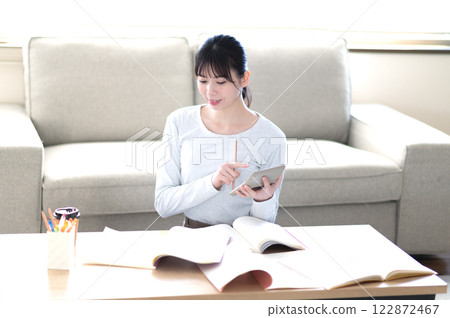 A young woman studying alone in the living room A young woman studying alone in the living room 122872467