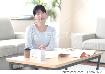 一位年輕女子獨自在客廳學習 122872635