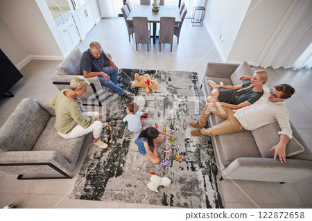 Big family in living room home with parents, baby or children play on carpet for growth, development and wellness. Overhead grandmother and grandfather talking to kids for language learning in lounge 122872658