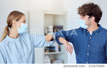 Business team, elbow bump and covid compliance with employees greeting with social distance in an office. Man and woman in the office during coronavirus wearing a face mask and working after lockdown Business team, elbow bump and covid compliance with employees greeting with social distance in an office. Man and woman in the office during coronavirus wearing a face mask and working after lockdown 122872660