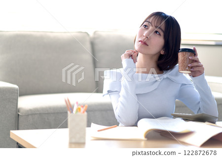 A young woman studying alone in the living room A young woman studying alone in the living room 122872678