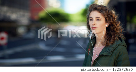 beautiful woman walking in city street listening to music wearing earphones urban lifestyle 122872680