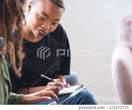 African american woman writing notes with friend showing ideas on digital tablet computer students brainstorming African american woman writing notes with friend showing ideas on digital tablet computer students brainstorming 122872725