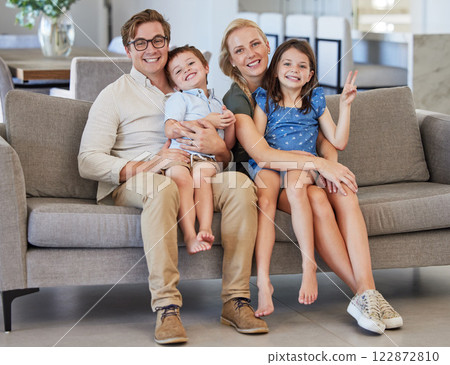 Mother, kids and father in a happy family portrait on sofa in a lovely home and enjoying quality time in the living room. Happiness, smile and young parents with smiling children relaxing together Mother, kids and father in a happy family portrait on sofa in a lovely home and enjoying quality time in the living room. Happiness, smile and young parents with smiling children relaxing together 122872810
