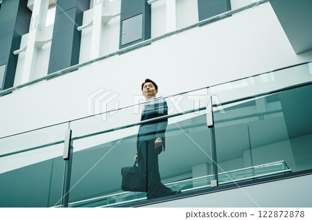 A young businessman in sales walking through a beautiful building 122872878