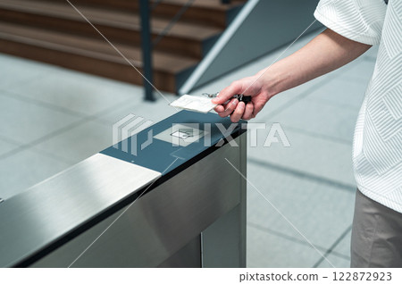 A man tapping his IC card on the security gate A man tapping his IC card on the security gate 122872923