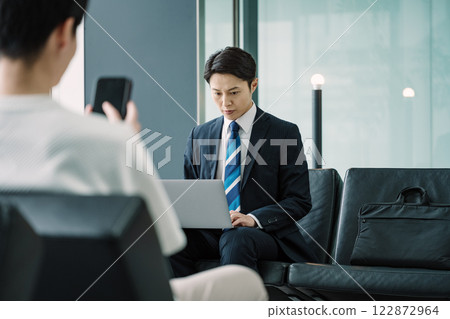 Businessman using laptop in waiting room lobby 122872964