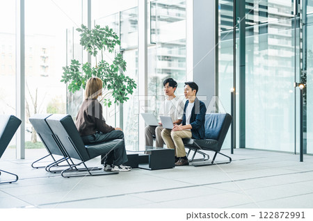 商務人士在寬敞的辦公大樓入口處討論業務 122872991