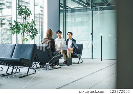 Business people discussing business at the entrance of a spacious office building 122872993