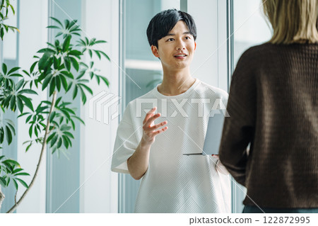 穿著休閒服的年輕工程師與同事交談 122872995