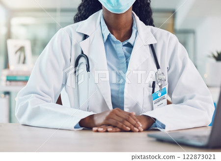 Covid face mask and doctor hands risk, safety and healthcare insurance advice with laptop for telehealth consultation. Medical black woman expert consulting in office and serious news of virus Covid face mask and doctor hands risk, safety and healthcare insurance advice with laptop for telehealth consultation. Medical black woman expert consulting in office and serious news of virus 122873021