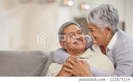 Relax, retirement and senior Mexico couple on sofa at home enjoying free time with smile, hug and love. Happy, comfortable and relationship of elderly man and woman on couch in living room together 122873114