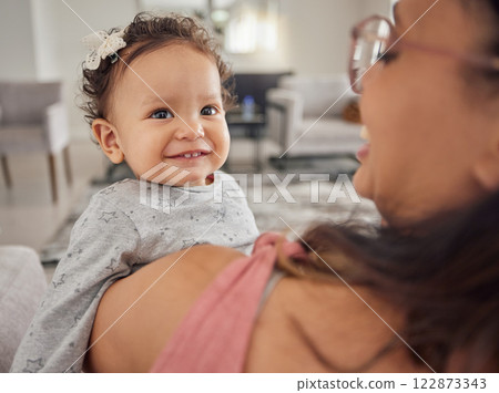 Family, mother and baby being funny at home, happiness and relax together in the living room at home. Happy, love and comic child and parent laughing at joke and smile with hug for care in house 122873343