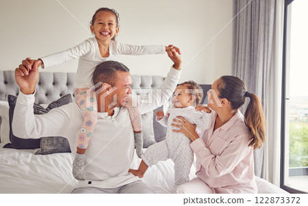 Comic family, happy and bedroom portrait while relax in home together, smile for parents love and international hotel holiday. Excited kids with mother and father on holiday and being playful in bed Comic family, happy and bedroom portrait while relax in home together, smile for parents love and international hotel holiday. Excited kids with mother and father on holiday and being playful in bed 122873372