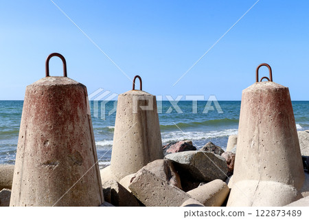Large concrete breakwaters on the seashore 122873489