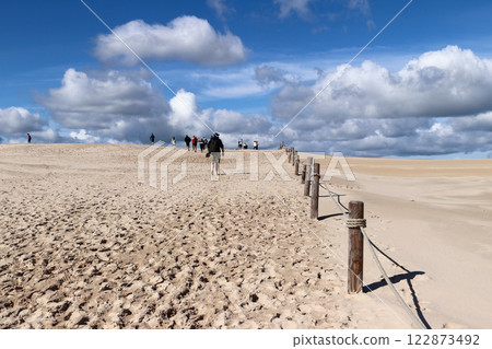 Beachgoers on the white sand dunes of Leba in the Slovincian National Park, Poland 122873492