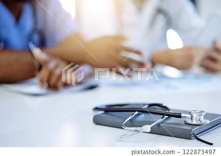 Stethoscope and notebook for cardiology or heart health in hospital meeting background and people discussion of healthcare clinic results. Medical device equipment for consulting or menopause concept 122873497