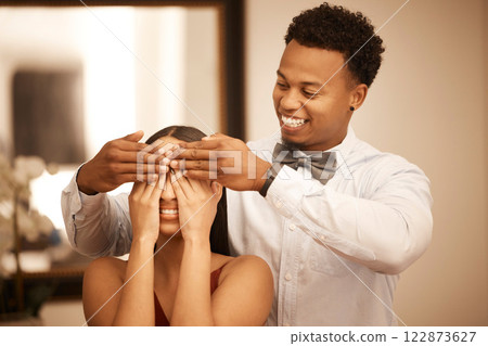 Love, couple and wow with the hands of a man on the eyes of a woman for a surprise during a celebration or date. Romance, dating and affection with a young couple looking happy with a smile at home 122873627